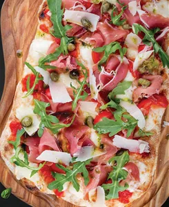 Pinsa mit Rucola, Rohschinken und Parmesan auf der Menükarte